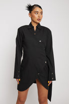 Close-up of the black asymmetric shirt dress showing the collar and button detail.