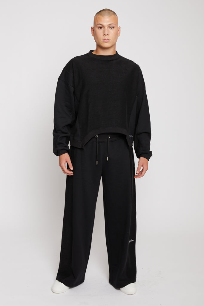Front view of a model in the men's black crew neck jumper and matching joggers.