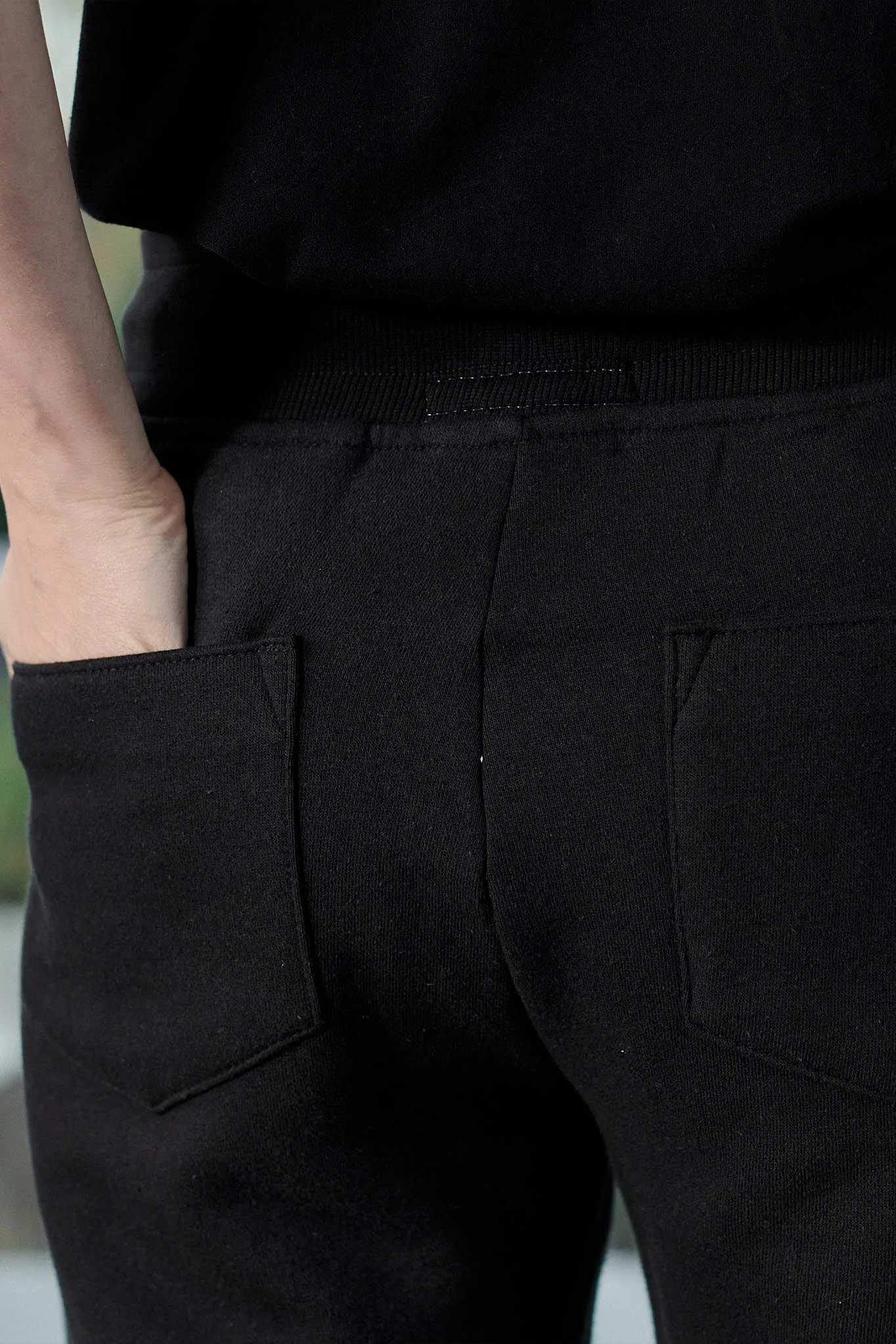 Close up texture view of the back pocket detail on mens black shorts