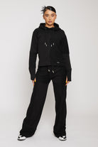 Model posing in wide leg black kroen joggers showing the relaxed fit