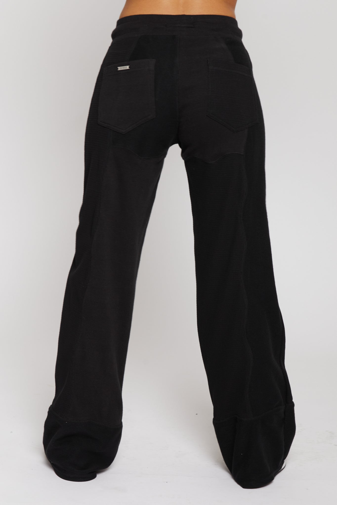 Side profile view showing the loopback fabric detail on black joggers