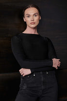 A model styled in the black racer neck bodysuit with jeans.