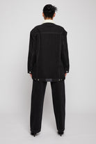 Back view of a model wearing the black shearling jean jacket.