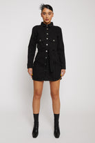 Front view of a model wearing the women's black washed denim dress with a tie belt