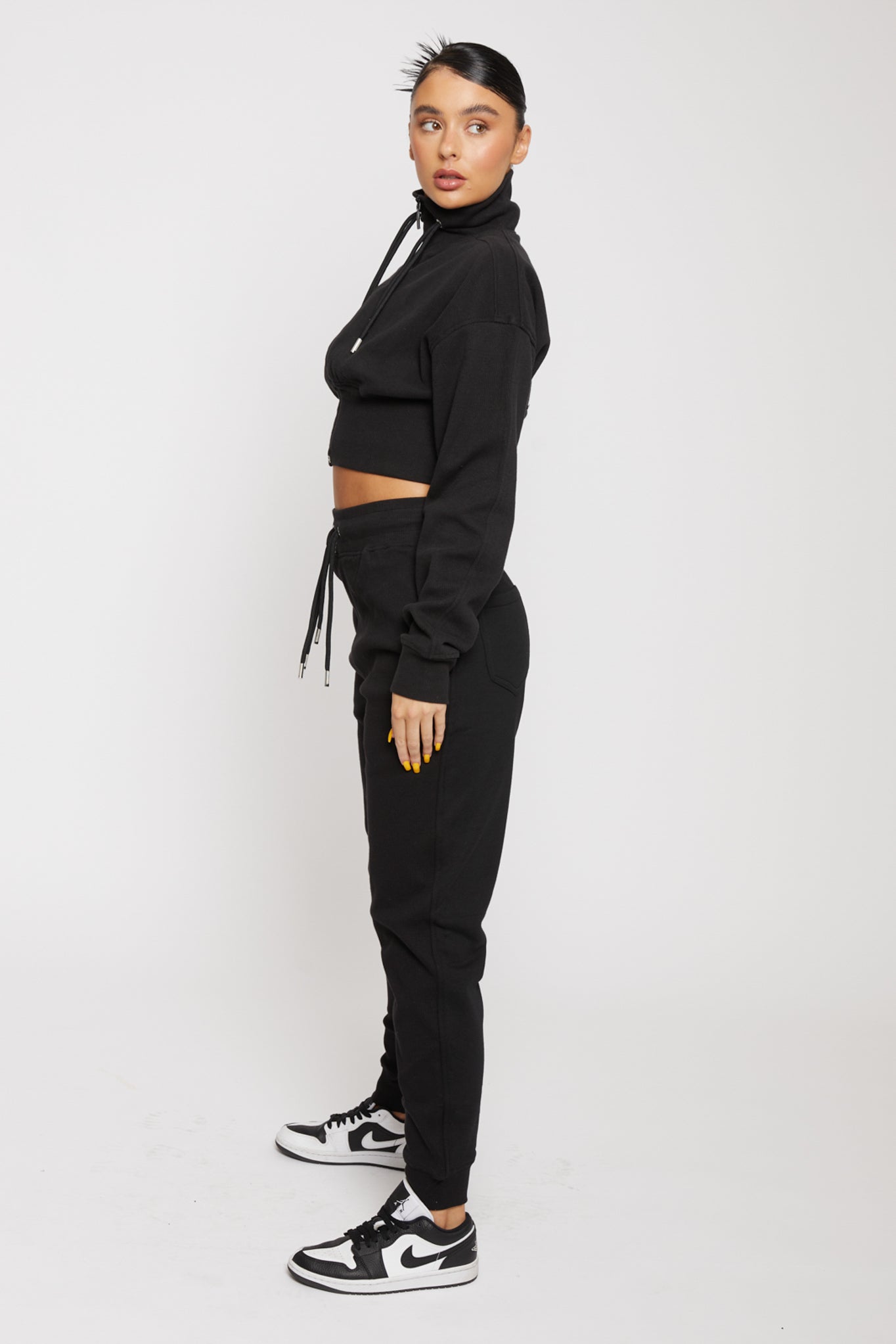Side profile view showing the fit of the black zip neck sweatshirt for women