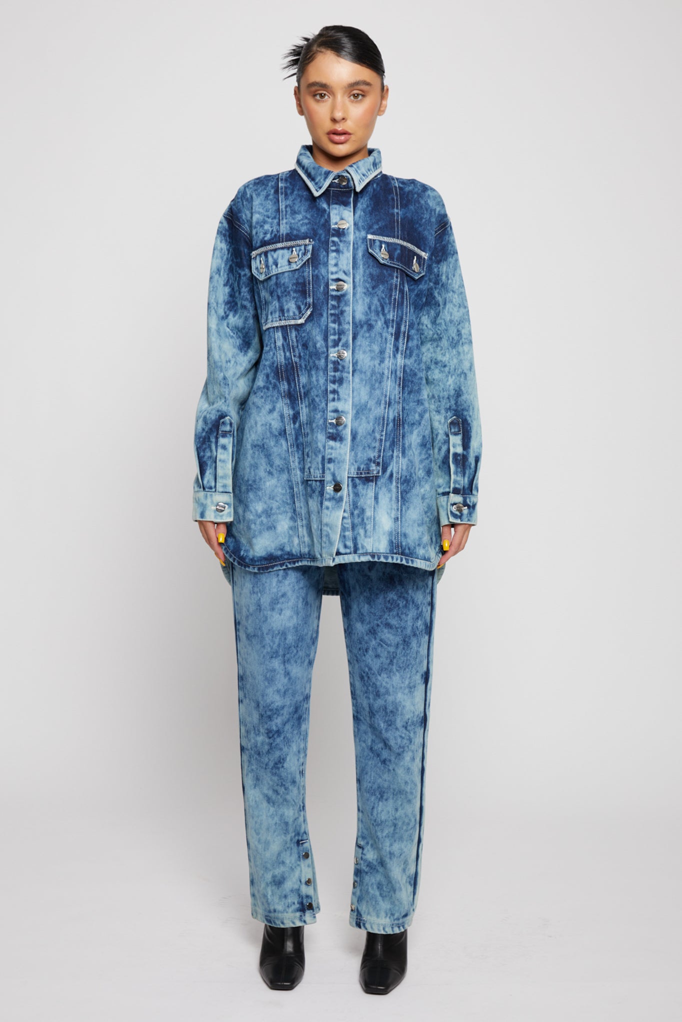 Full front view of a model in the bleach wash denim shirt and jeans set.