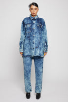 Full front view of a model in the bleach wash denim shirt and jeans set.