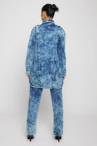 Back view of a model in the women's bleach wash denim shirt and matching jeans.