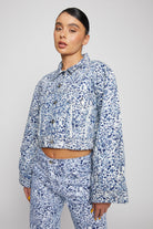 A model wearing the blue and white marble print denim jacket.