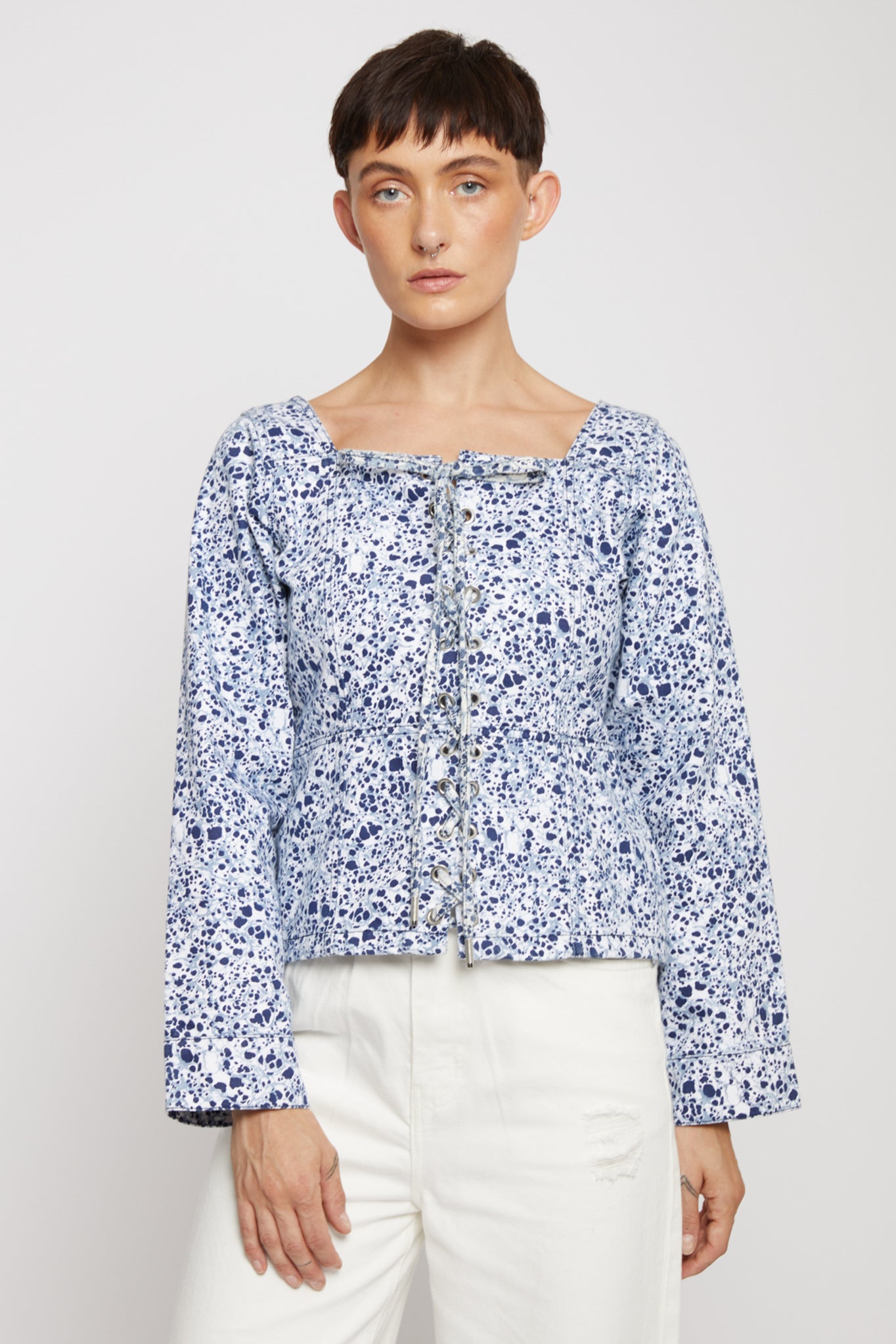 Front view of the women's blue marble print top with a square neck and lace-up front.