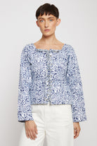 Front view of the women's blue marble print top with a square neck and lace-up front.
