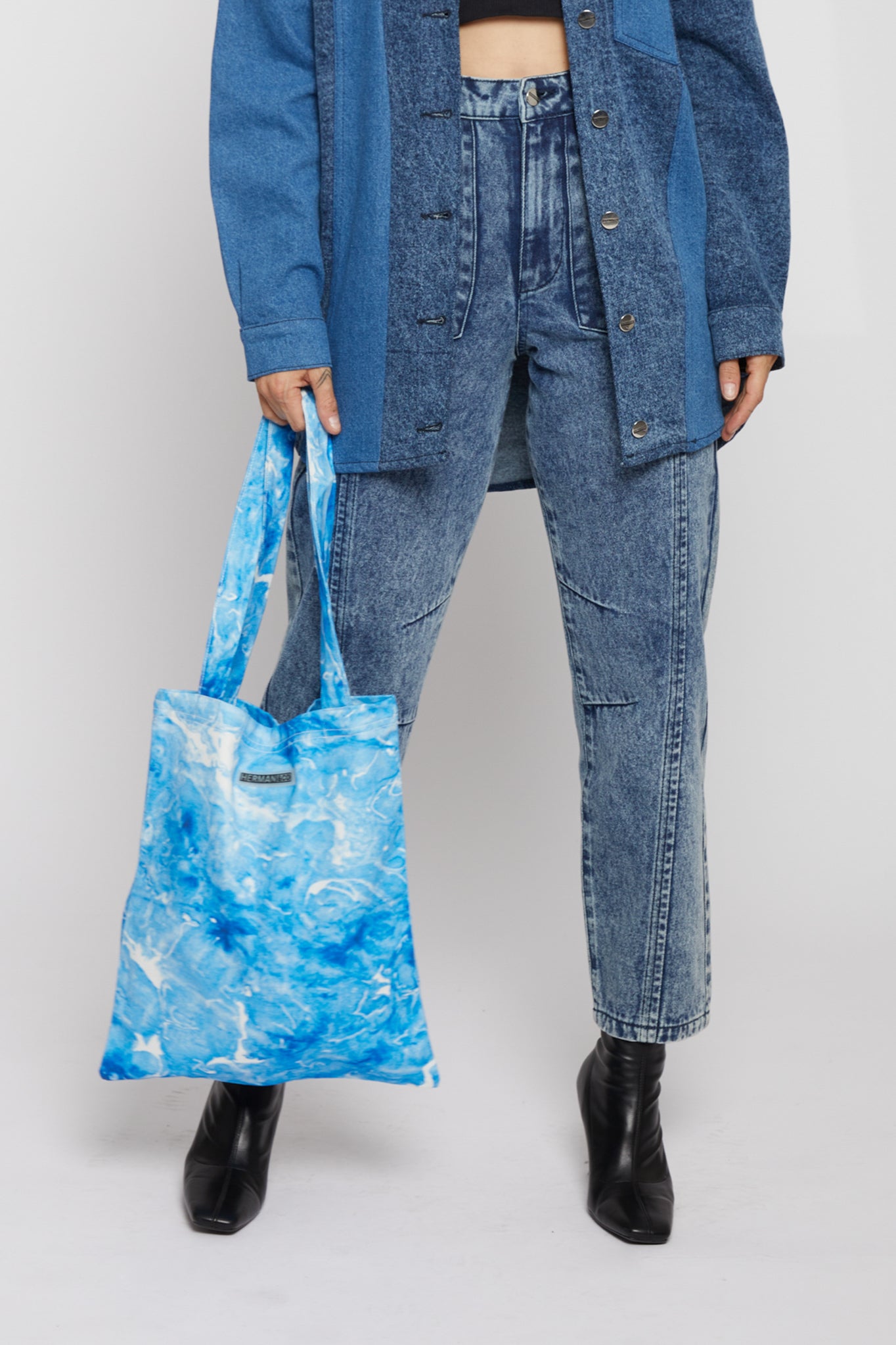 A model holding the women's blue printed denim tote bag.