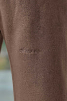 Close-up of the 'Fit For All' tonal embroidery on the men's brown joggers