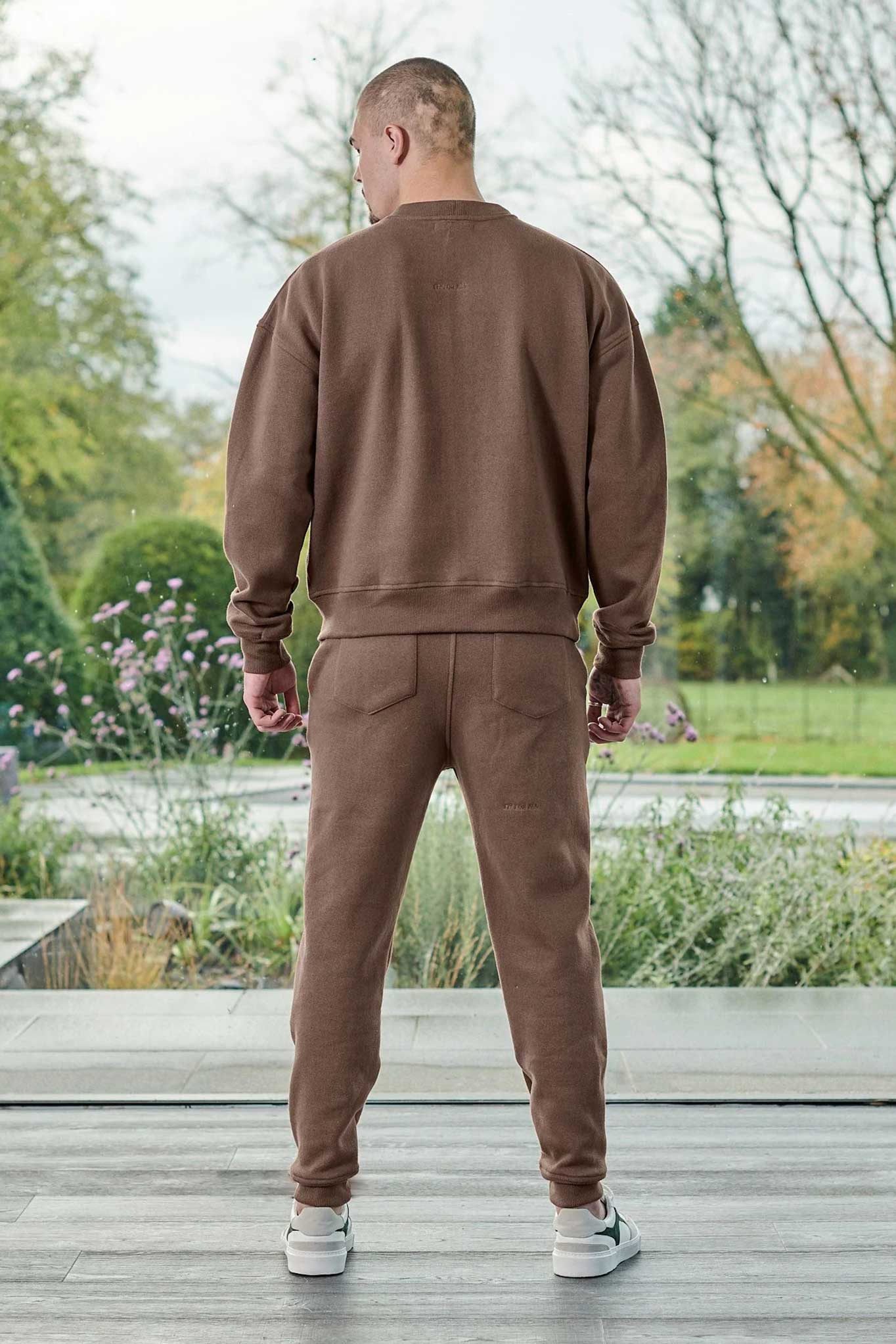 Back view of a model wearing the brown tapered joggers for men.