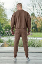 Back view of a model wearing the brown tapered joggers for men.