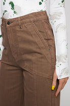 Close-up of the front pocket detail on the brown wide-leg baggy jeans.