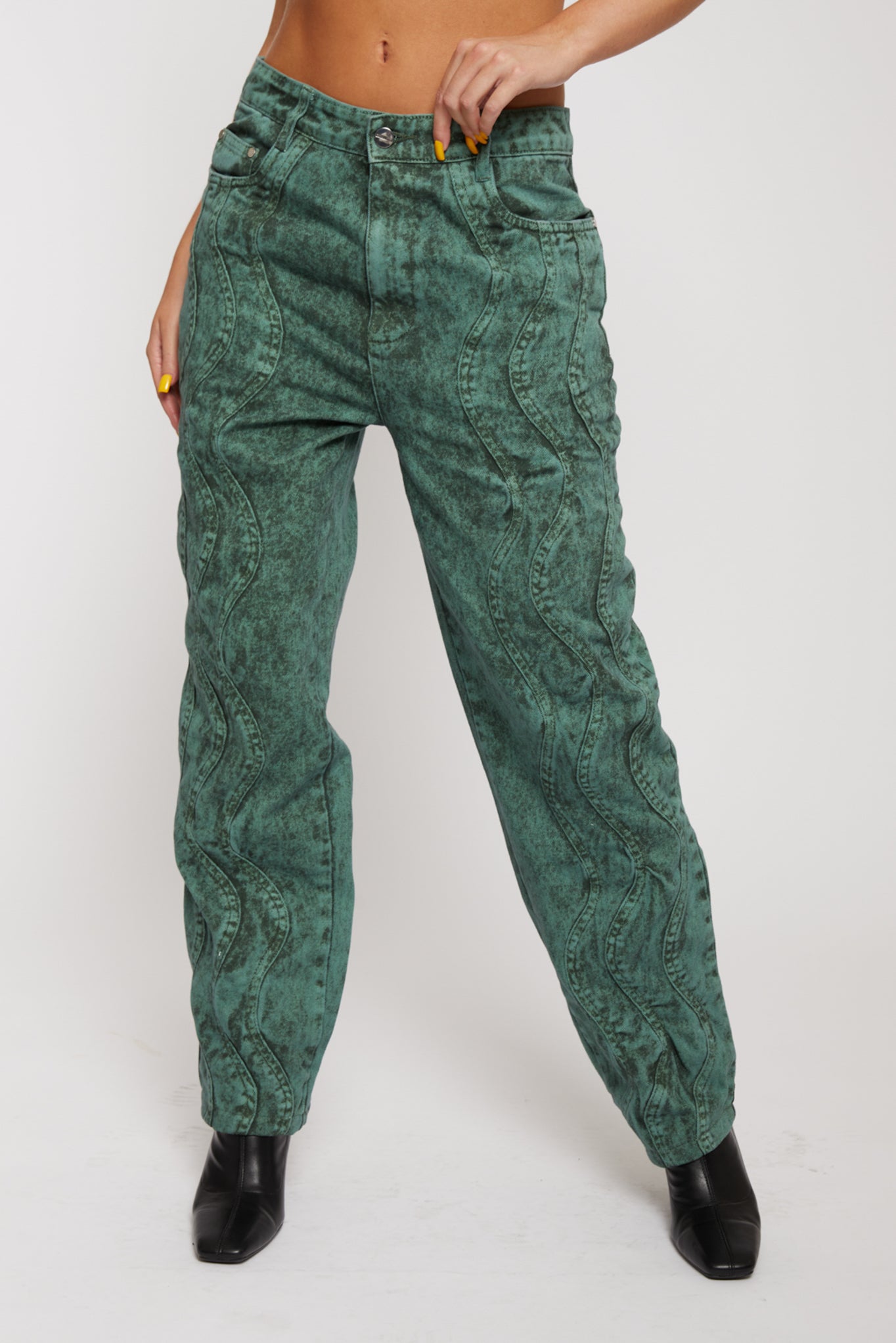 Close-up of the dark green acid wash baggy jeans with a wavy pattern.