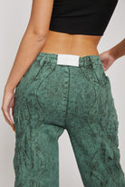 Close-up of the logo patch on the back of the dark green jeans.