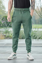 Close up detail of the drawstring waist and pockets on dark green joggers mens