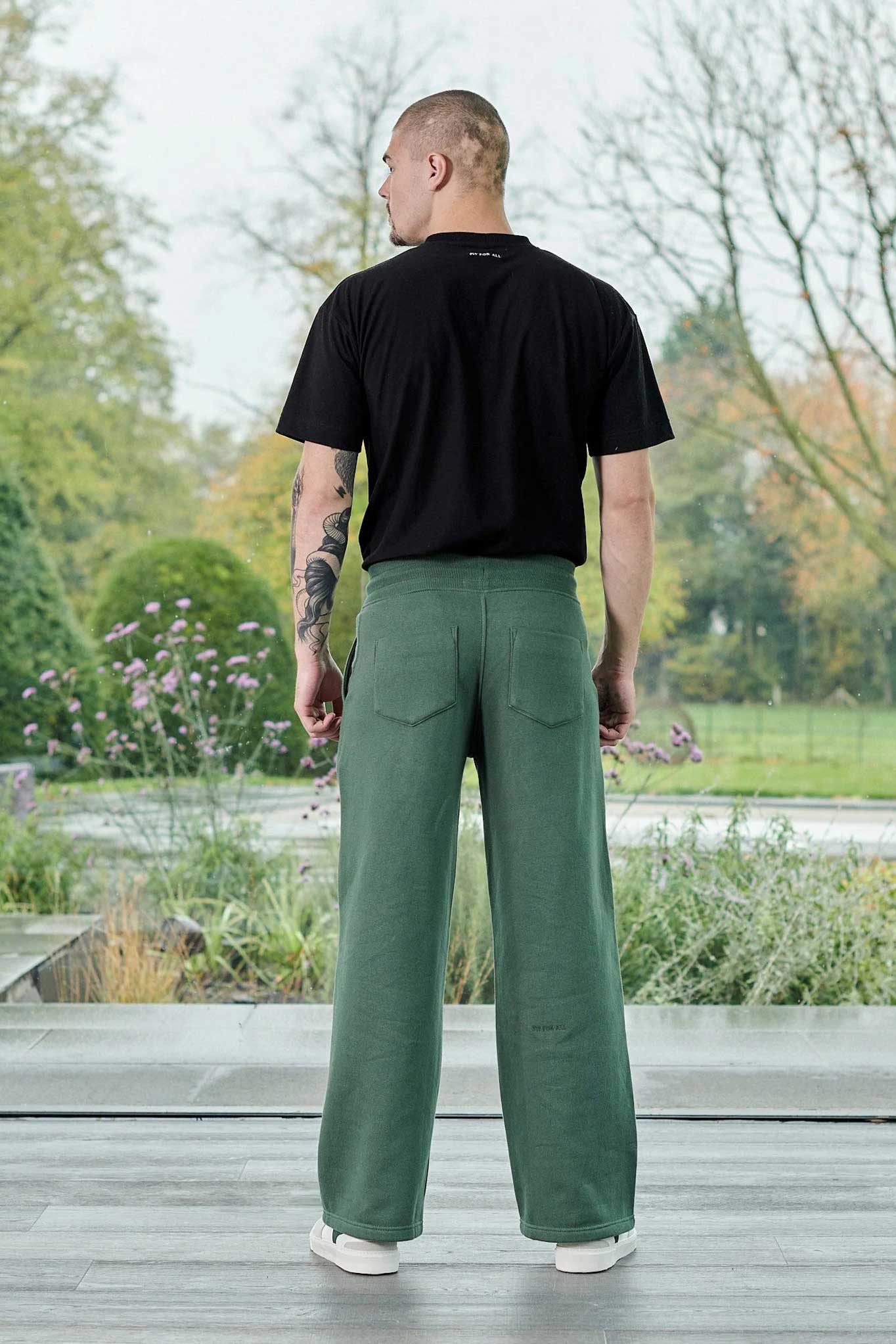 Back view of a model in the dark green wide-leg joggers