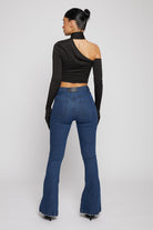 Back view of a model wearing the dark wash flare jeans with distressing.