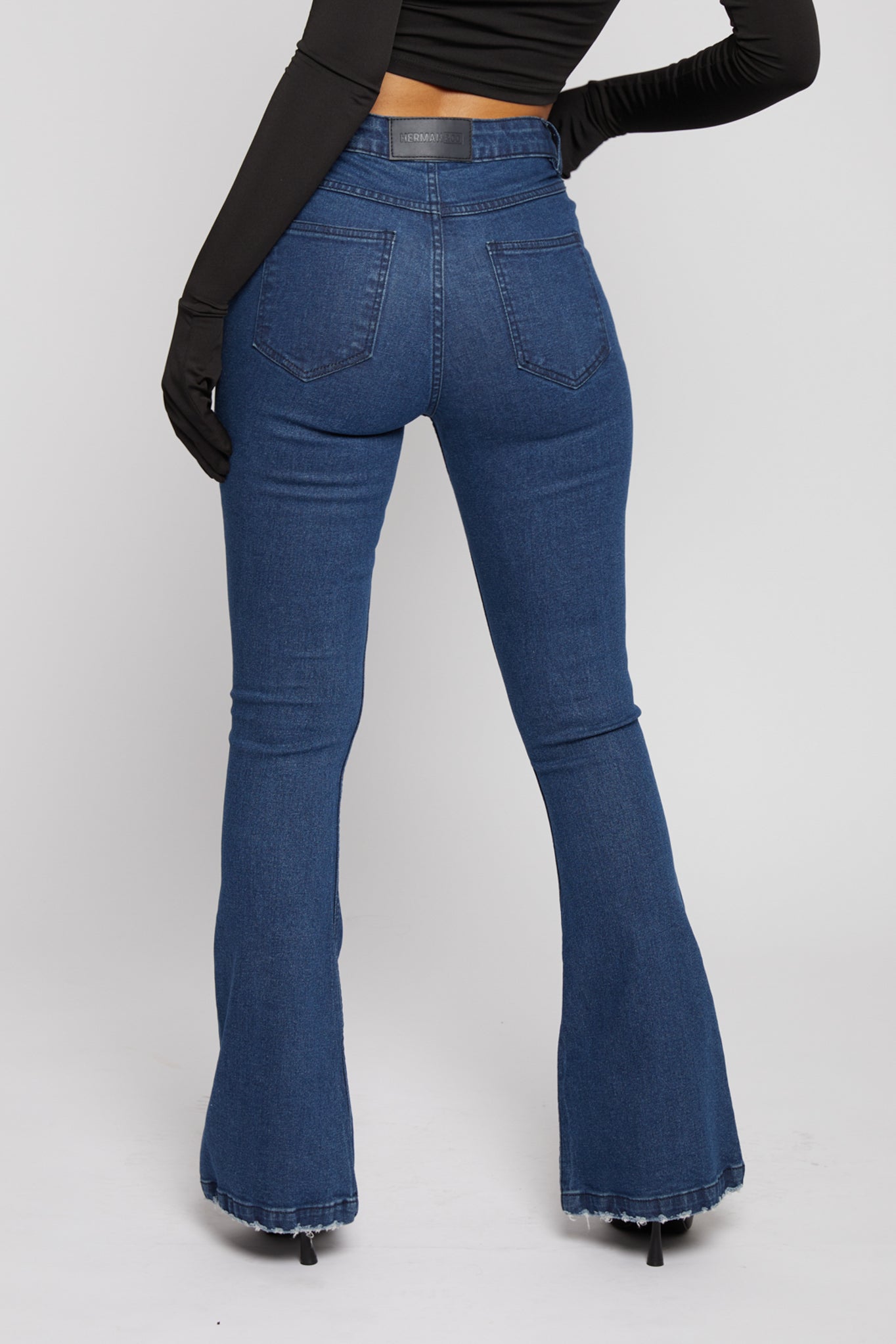 Close-up of the back pockets and fit of the distressed flare jeans.