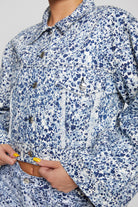 Close-up of the chest pocket and distressed details on the marble denim jacket.