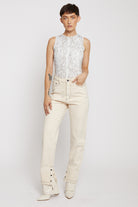 Front view of a model wearing ecru straight leg jeans with contrast stitching.