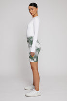 Side profile of a model showing the fit of the green printed cycling shorts.