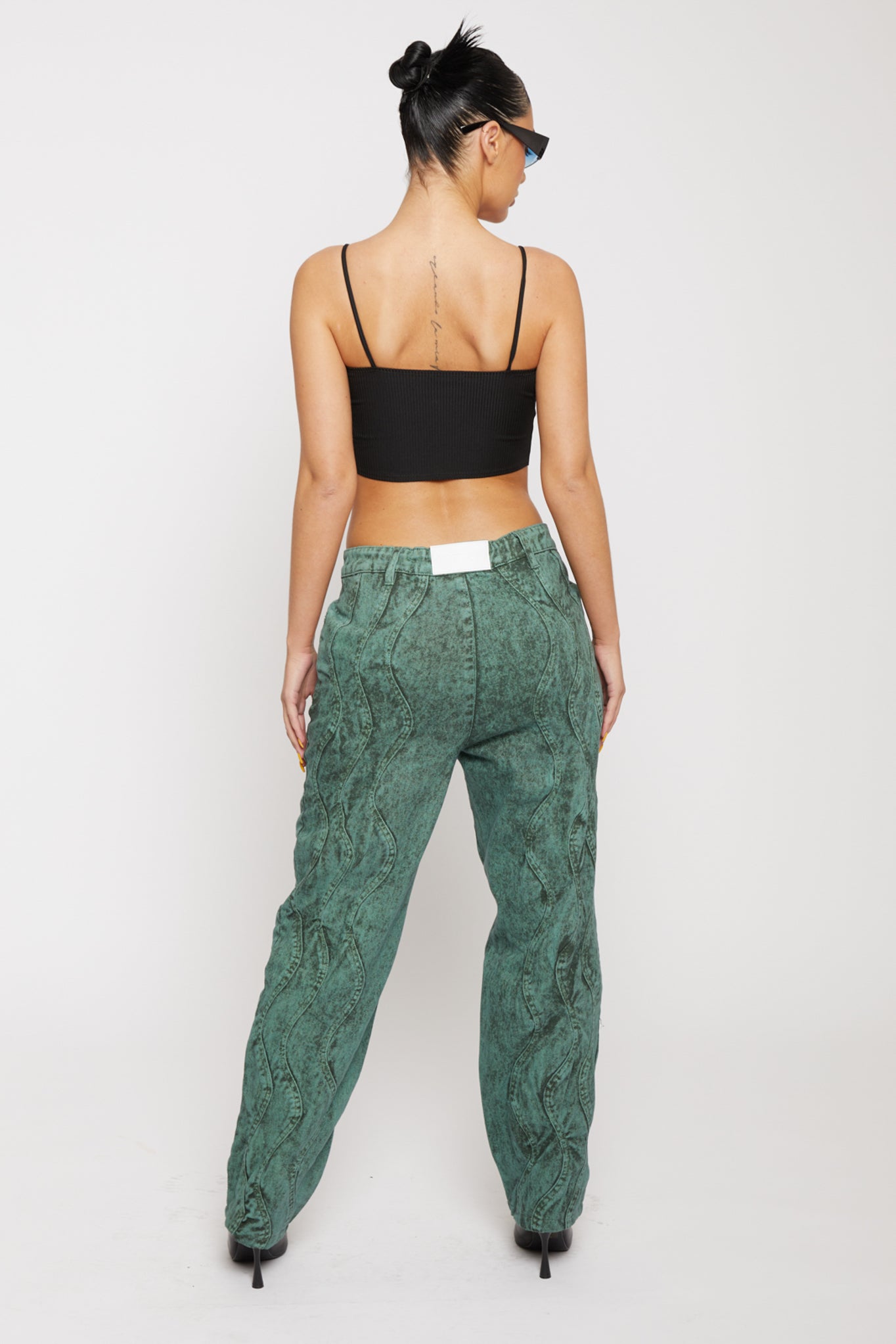Back view of a model in green wash baggy jeans showing the fit.