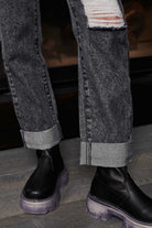 Close-up of the stylish turn-up hem on the grey acid wash jeans