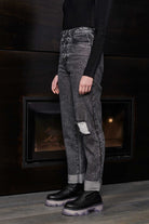 Side profile of a model wearing grey wash mom jeans to show the straight leg cut