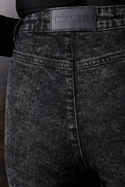 Close-up of the black Herman & Co logo patch on the back of the jeans