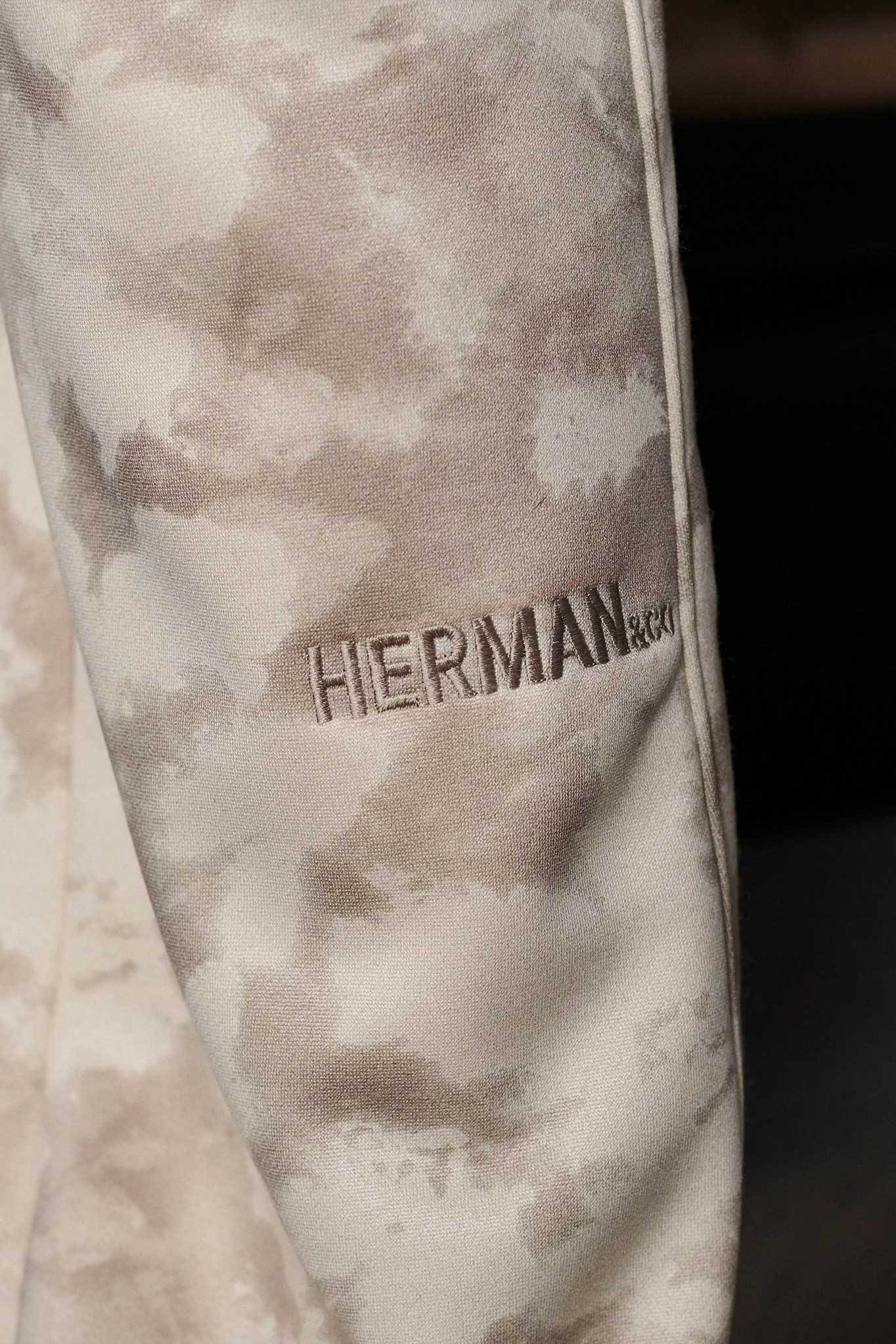 Close up detail of the HERMAN logo on the leg of beige joggers