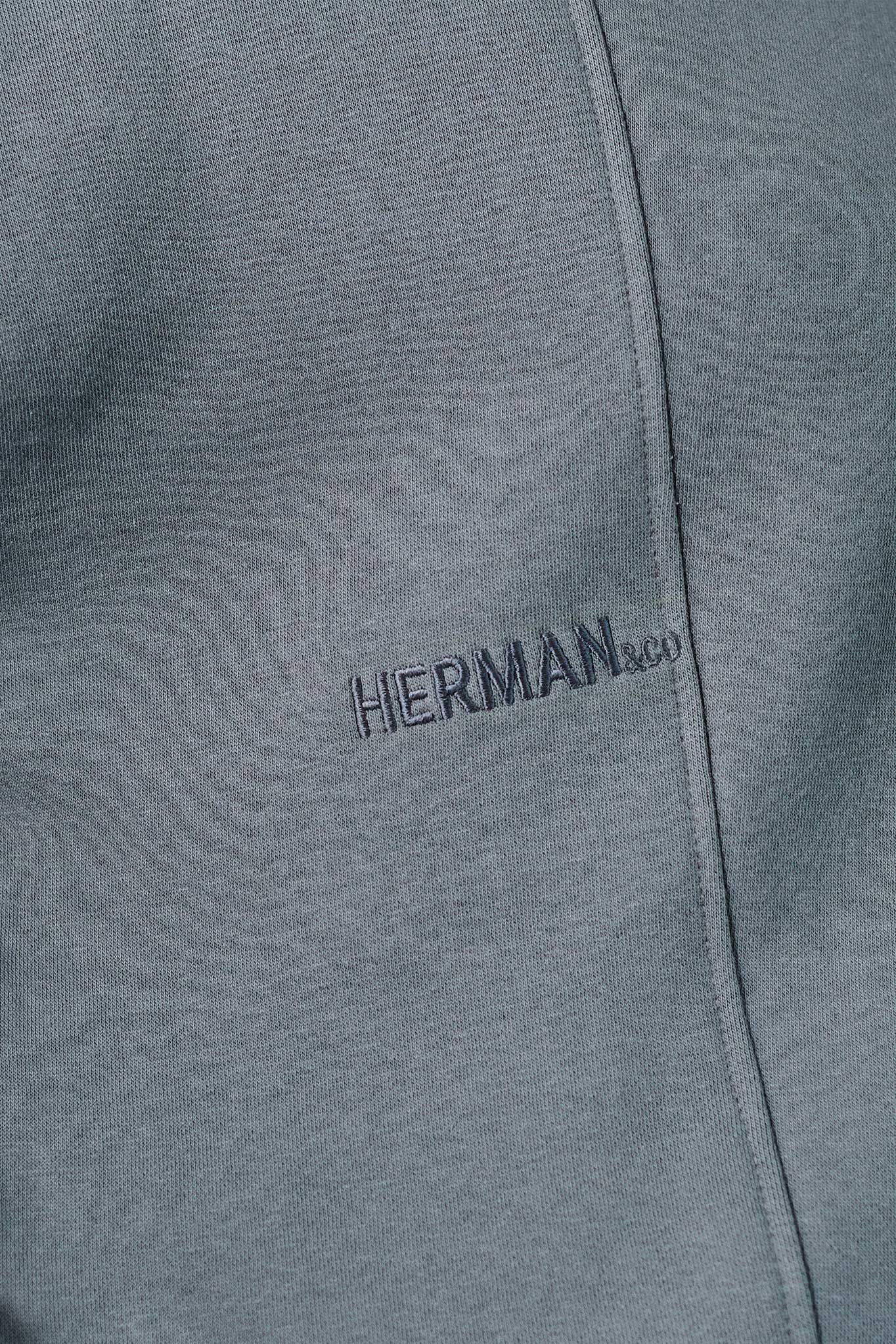 Close up detail of HERMAN text embroidery on grey jumper chest