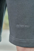 Detailed view of the tonal logo embroidery on the leg of cool grey shorts