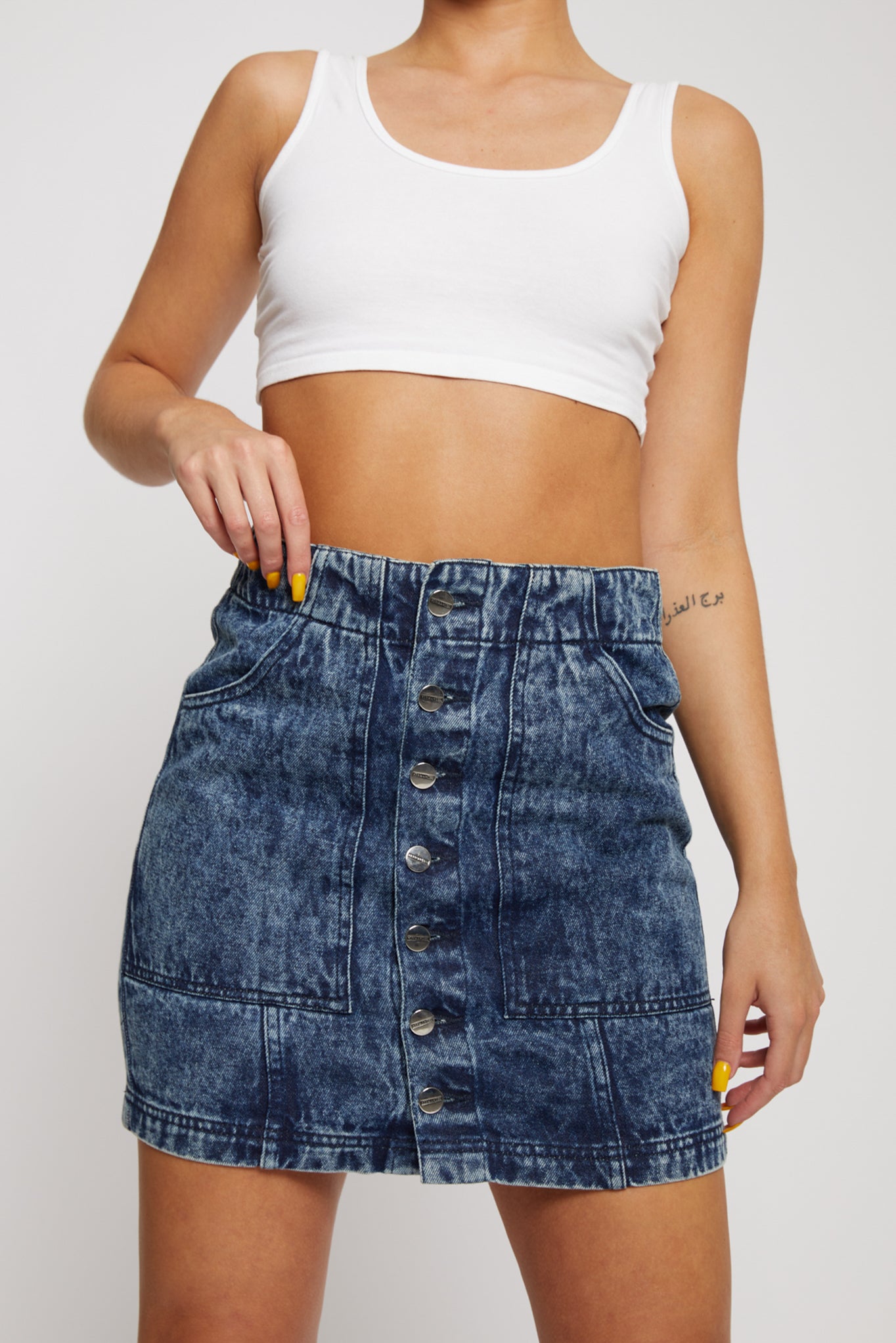 Close-up of the high-waisted fit of the acid wash denim skirt