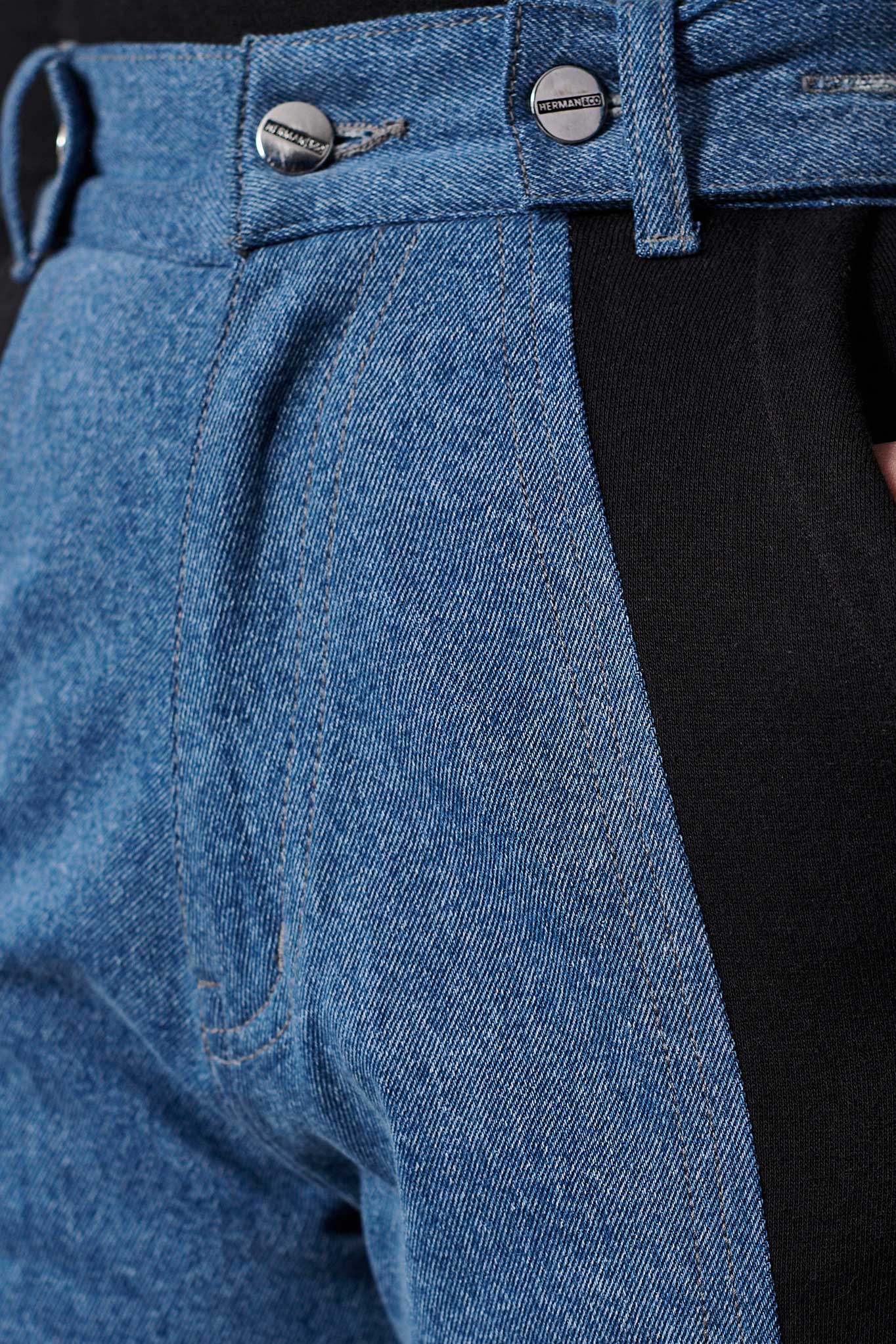 Detailed view of the waist on the jean joggers, showing the panel and buttons