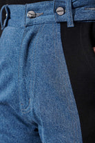 Detailed view of the waist on the jean joggers, showing the panel and buttons