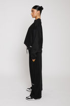 Model posing in ladies wide leg jogger black showcasing the mixed fabric detail