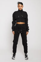 Model wearing ladies' black tapered joggers with a matching cropped hoodie