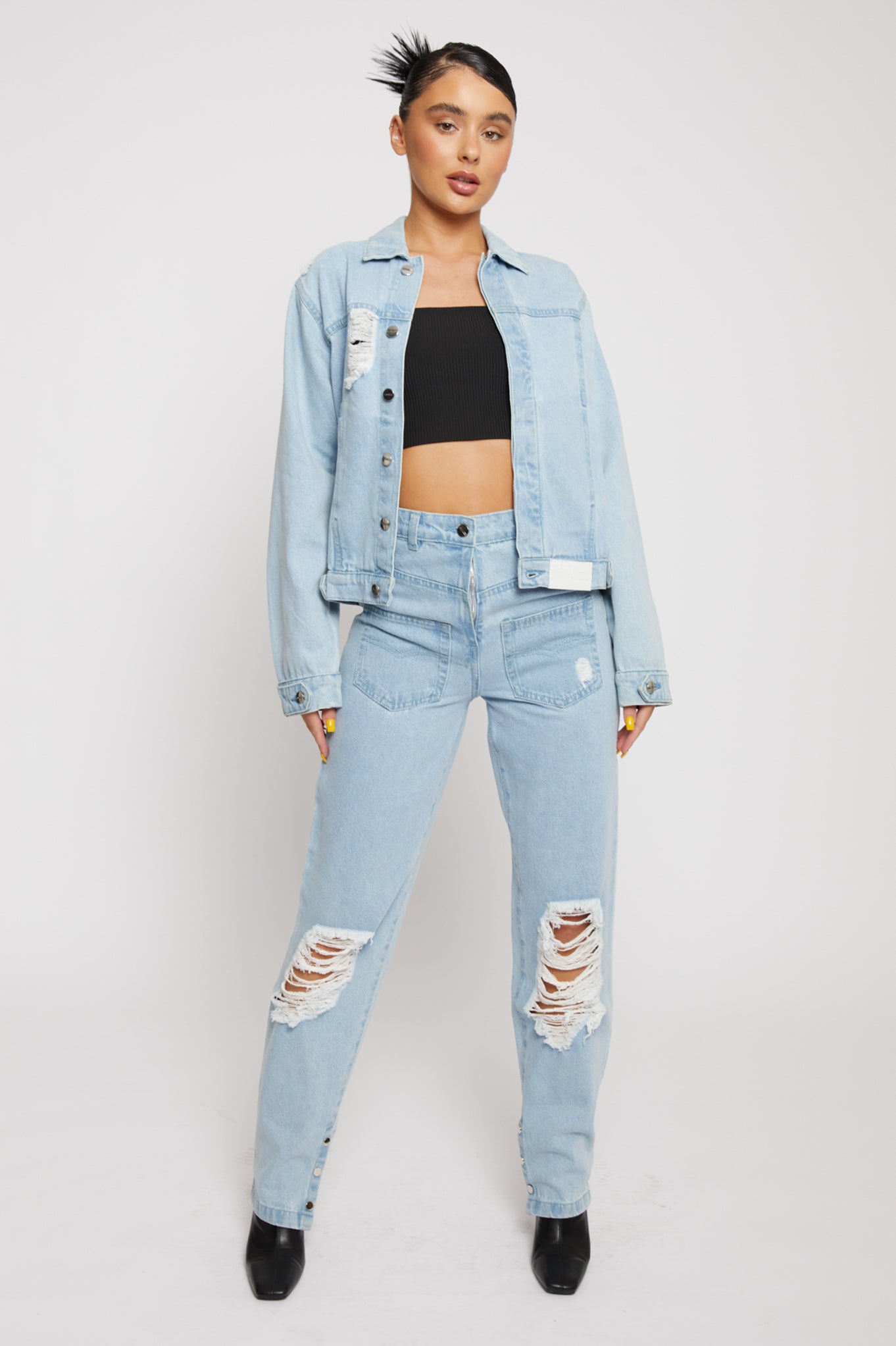 A model wearing the women's light wash distressed denim jacket.