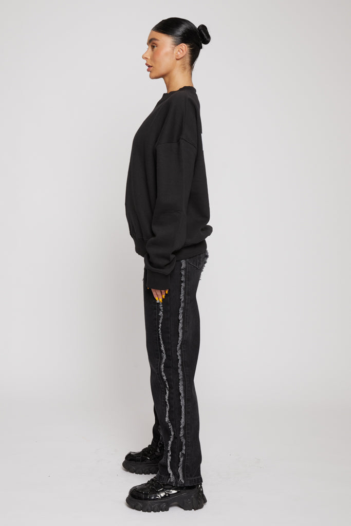 Side profile view showing the relaxed fit of the black crewneck sweatshirt for women