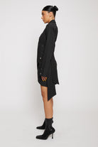 Side profile of the long-sleeve asymmetric shirt dress showing the draped detail.