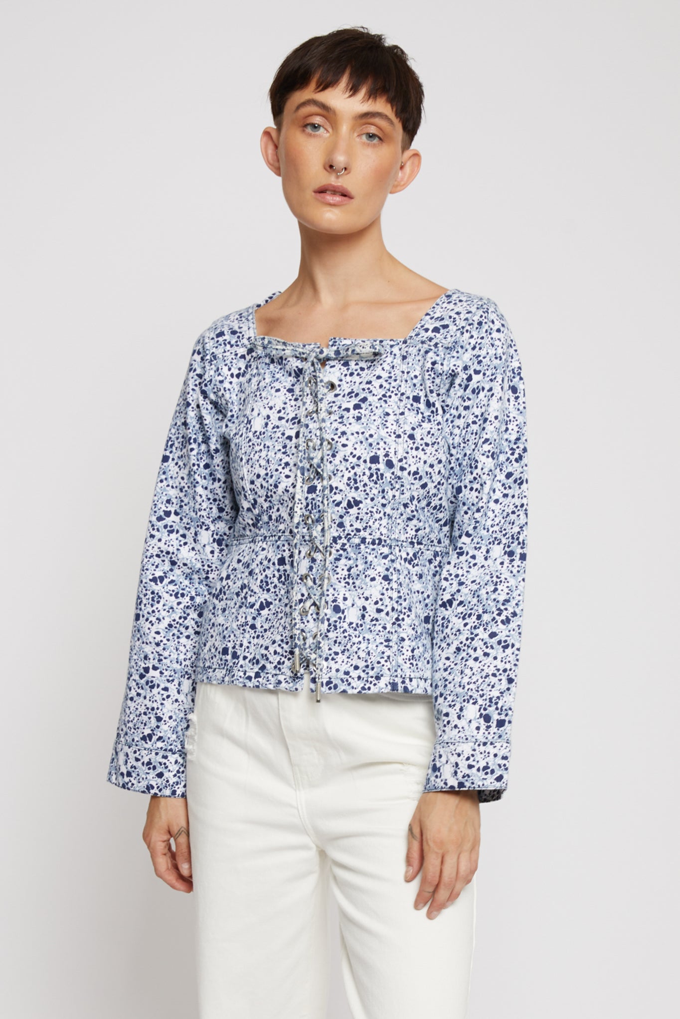 Front view of a model in the marble print long-sleeve lace-up top.