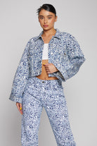 Model wearing the marble print cropped denim jacket with matching jeans.