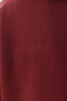 Close-up of the tonal 'Fit For All' embroidery on the maroon zip-up hoodie
