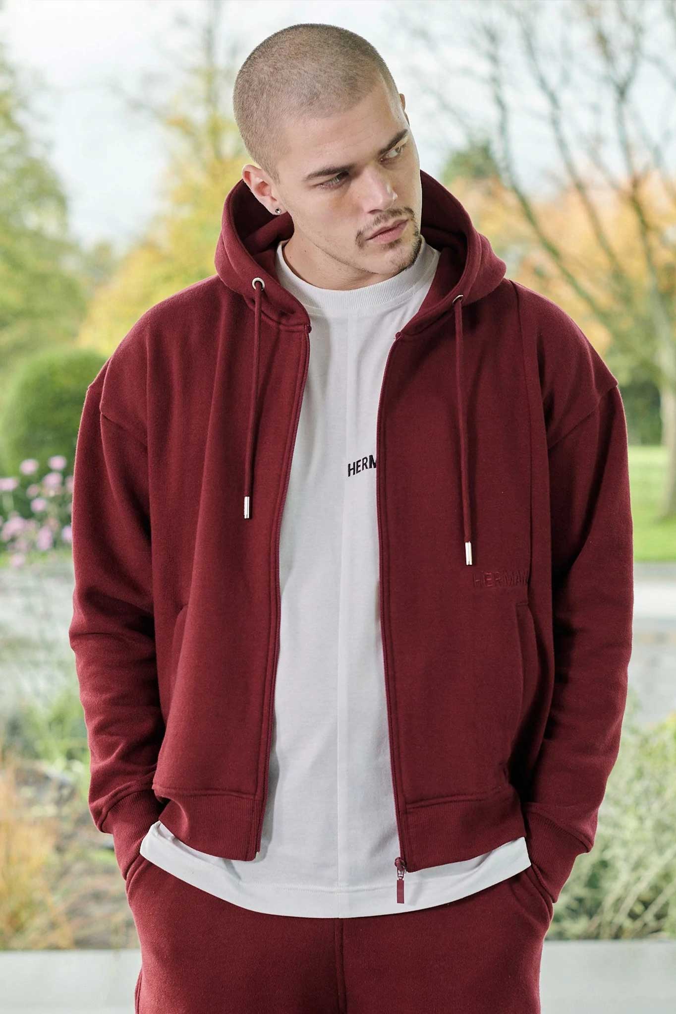 A model wearing the maroon zip-up hoodie for men open with a white t-shirt