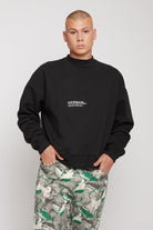Close-up of the men's black crew neck jumper.