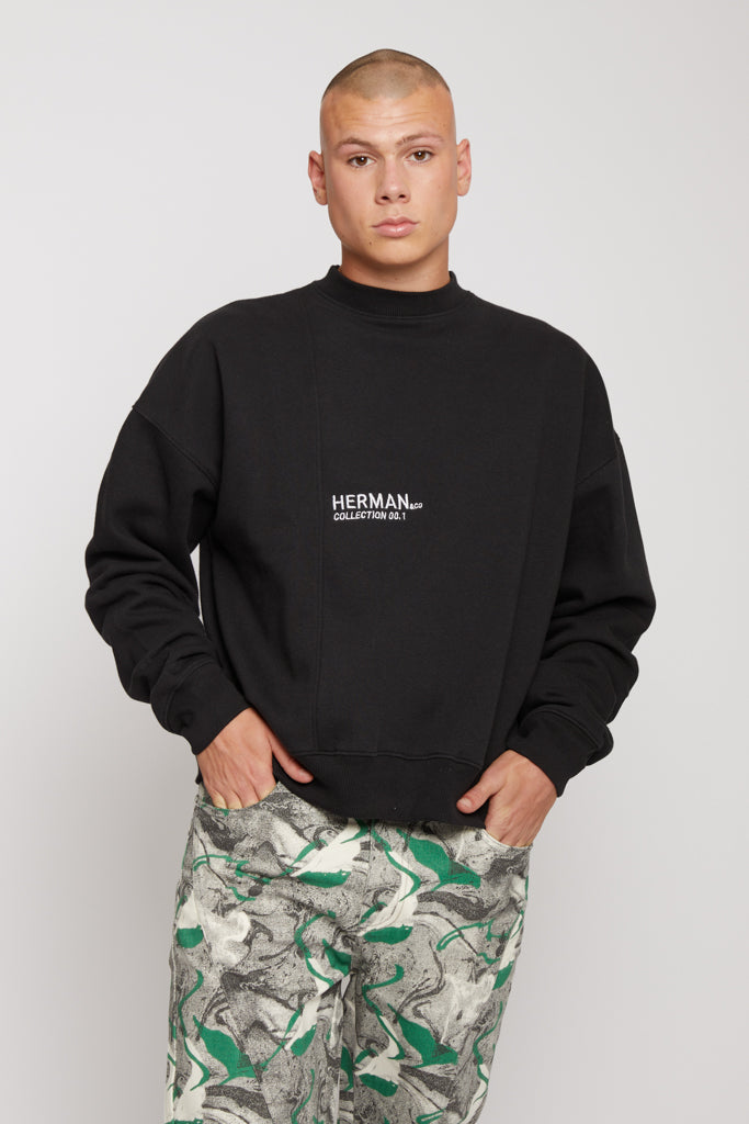 Close-up of the men's black crew neck jumper.